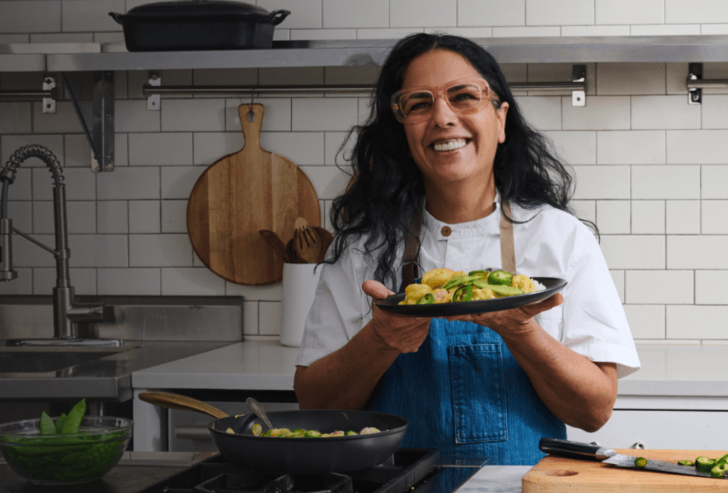 A Cook Unity chef holding a prepared and plated meal. 